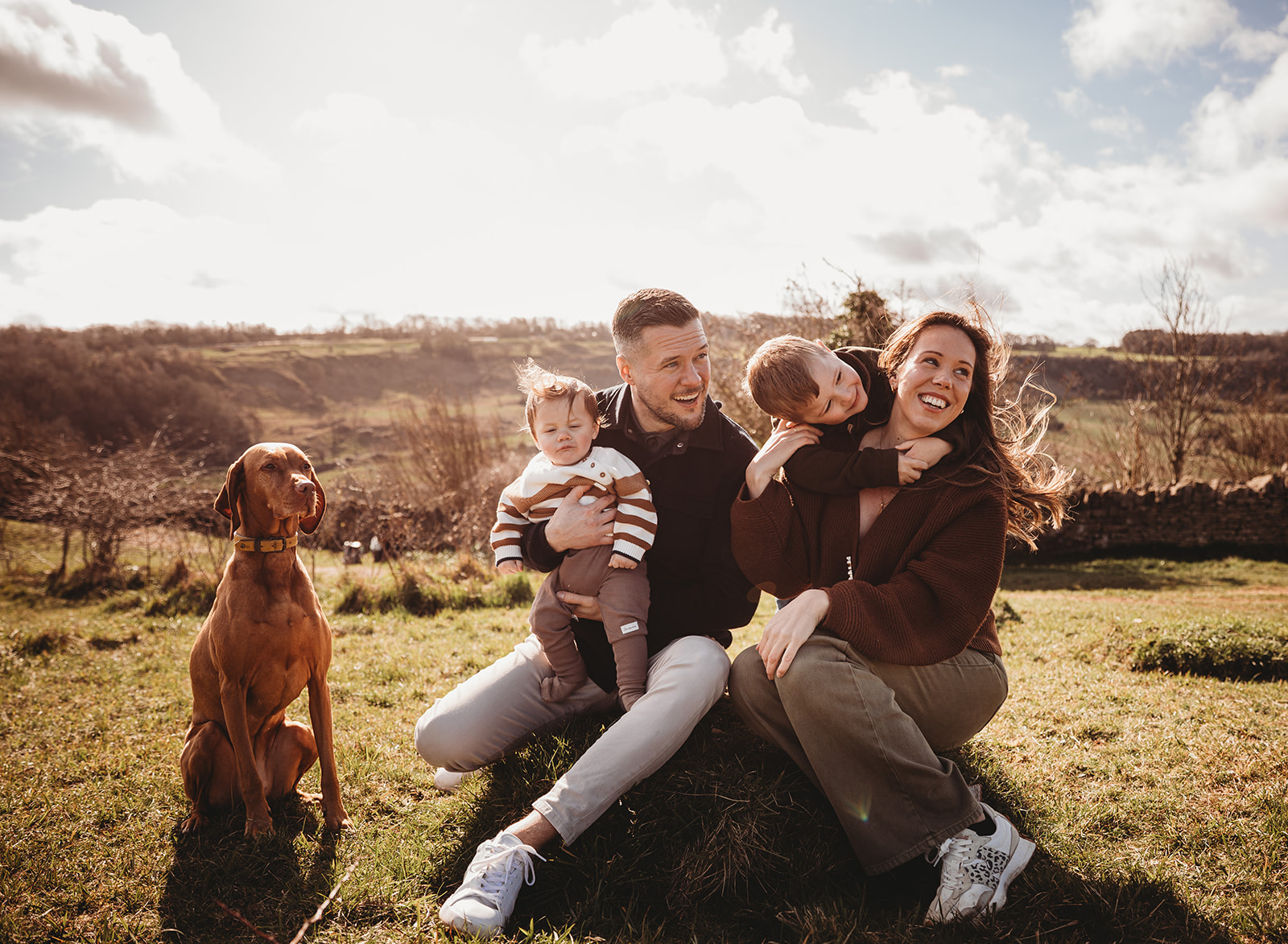 Two toddler siblings hugging and laughing at crickley hill family photoshoot to show that photography should be fun for children so they won't have a meltdown.