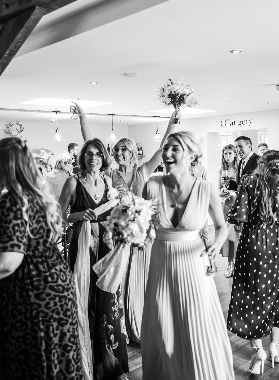 Cheerful wedding reception at the orangerie at Bredenbury Court barns, black and white image