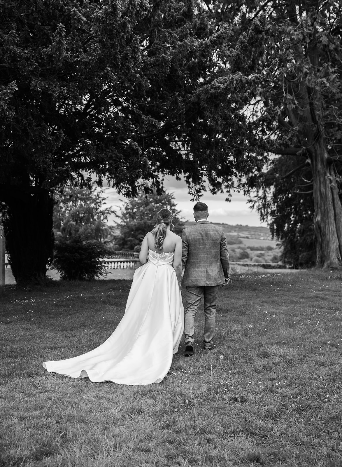 Black and white walking photo of bride and groom at bredenbury court barns in Herefordshire