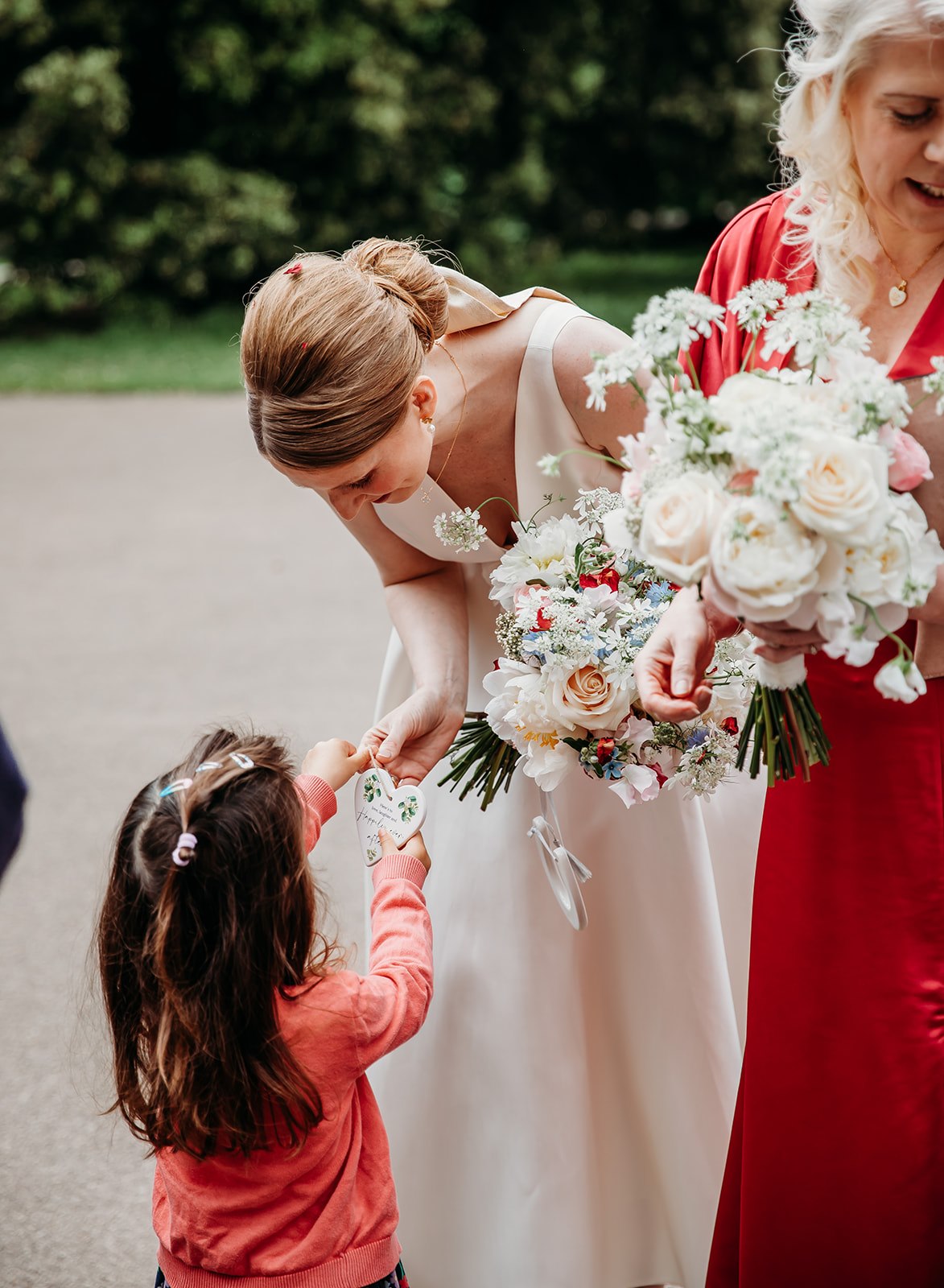 Bride is given a gift outside Pittville Pump Room after her wedding ceremony