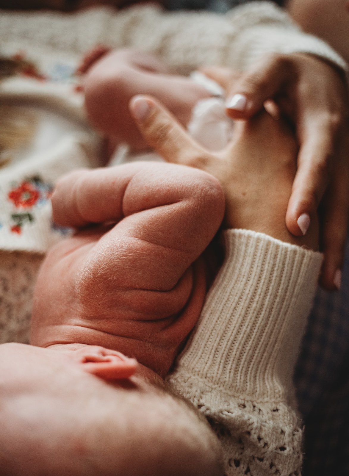 An emotive, grainy lifestyle photograph of a mother and daughter huddled together in a deep embrace, focusing on the intimate bond and natural outdoor lighting.